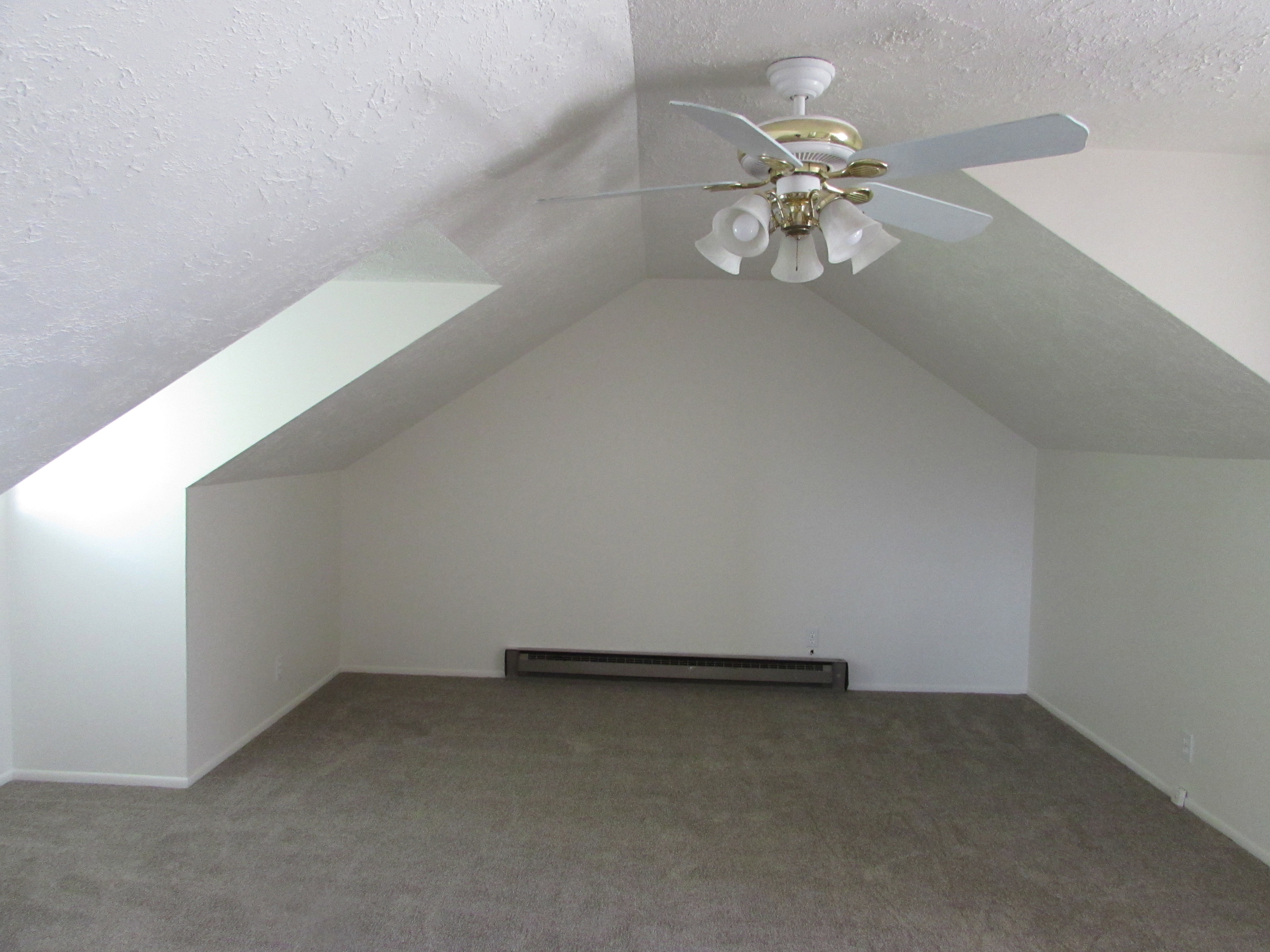 Bedroom with carpet floors, a baseboard radiator, and a ceiling fan