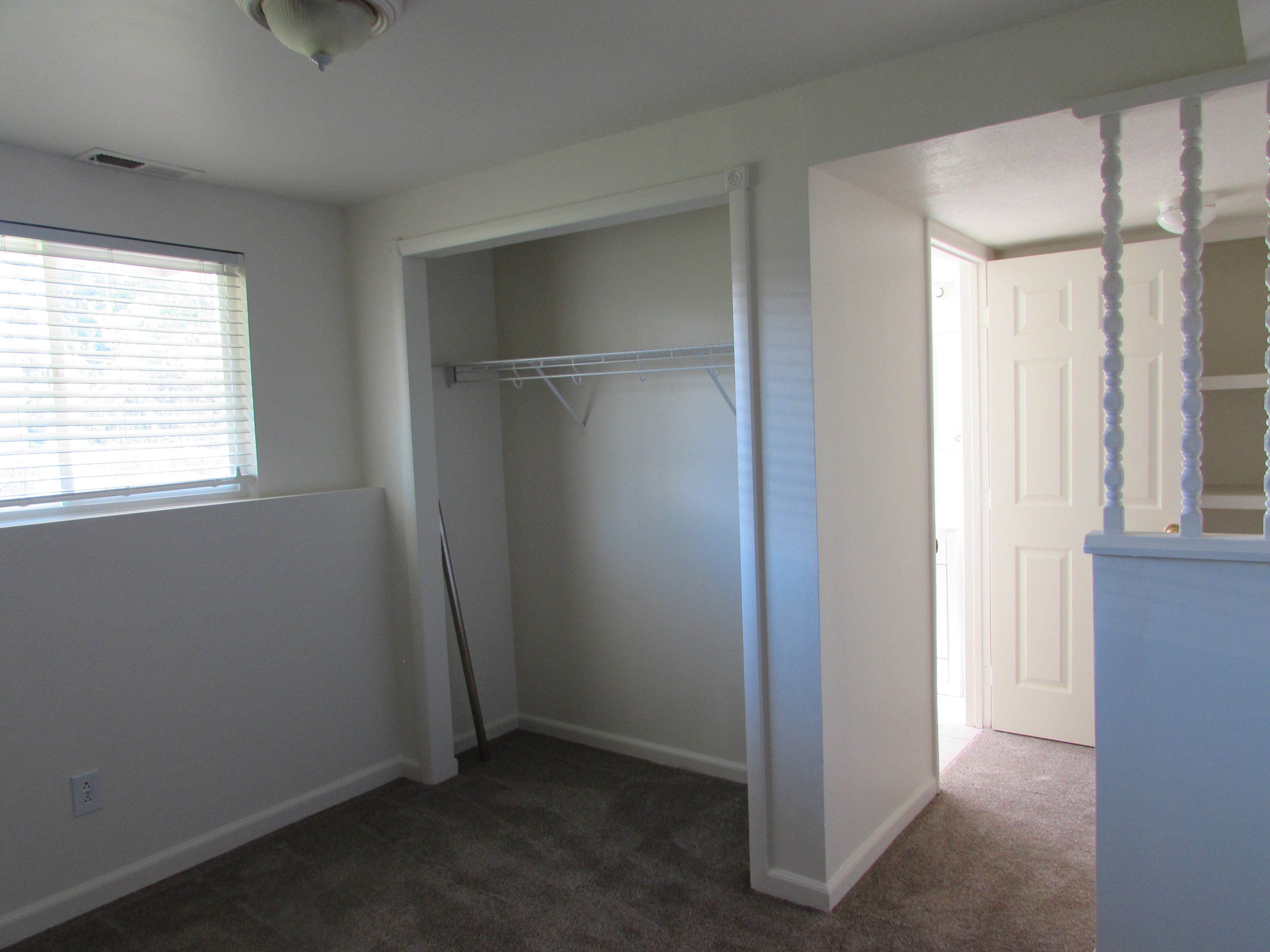 Unfurnished bedroom featuring new colored carpet and a closet