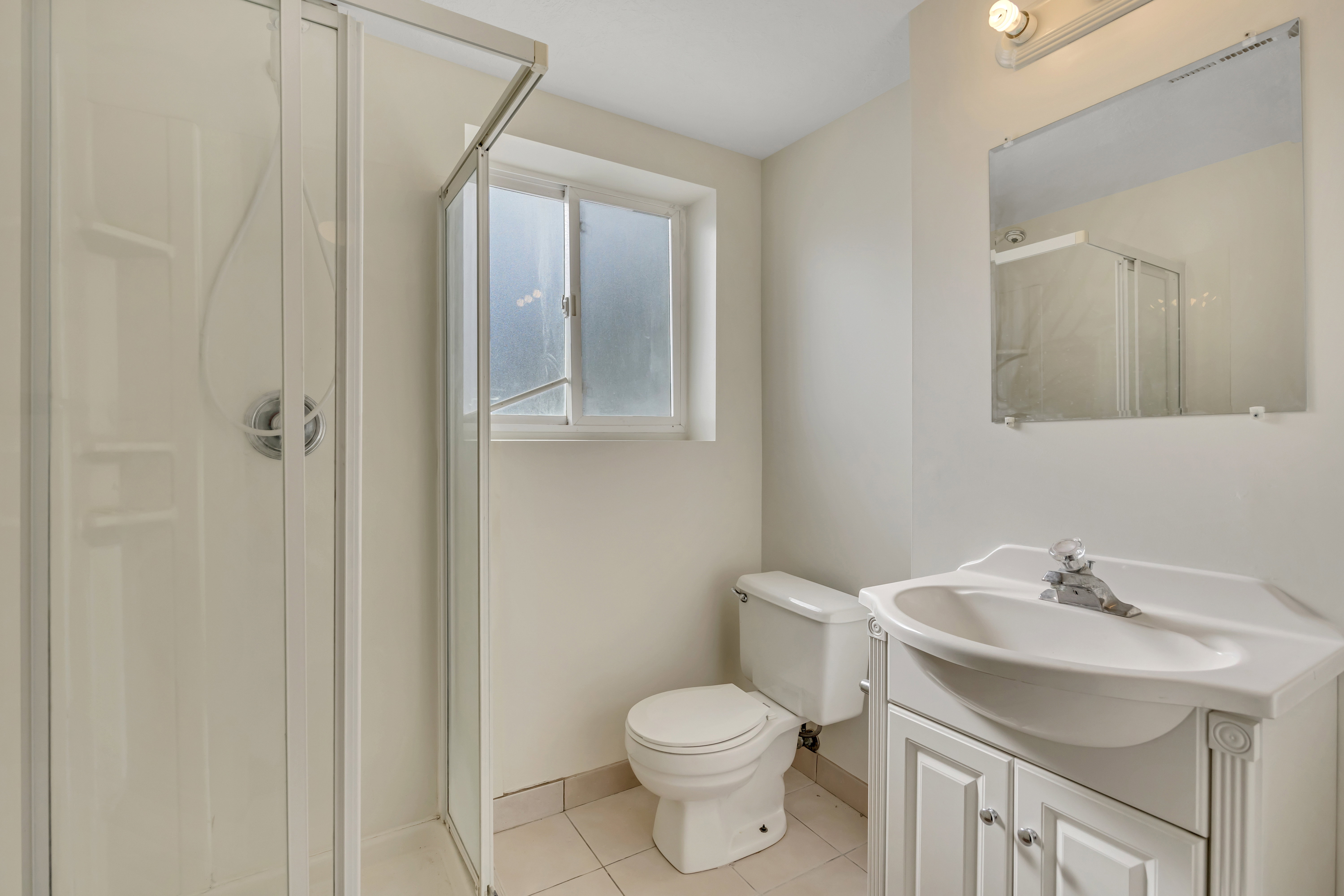 3/4 bath with vanity, a shower stall, and light tile patterned floors