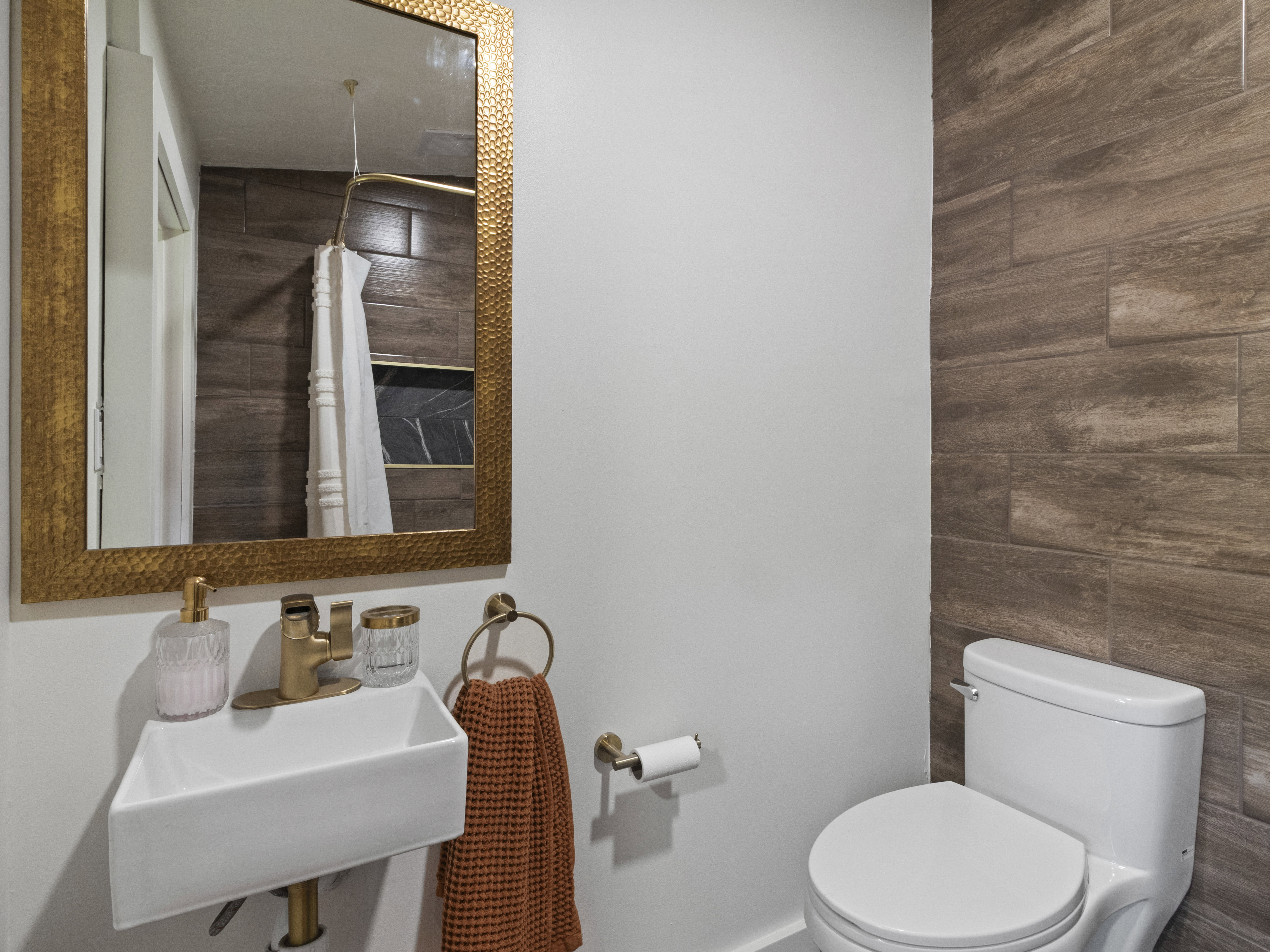 Full bath featuring curtained shower and wood walls