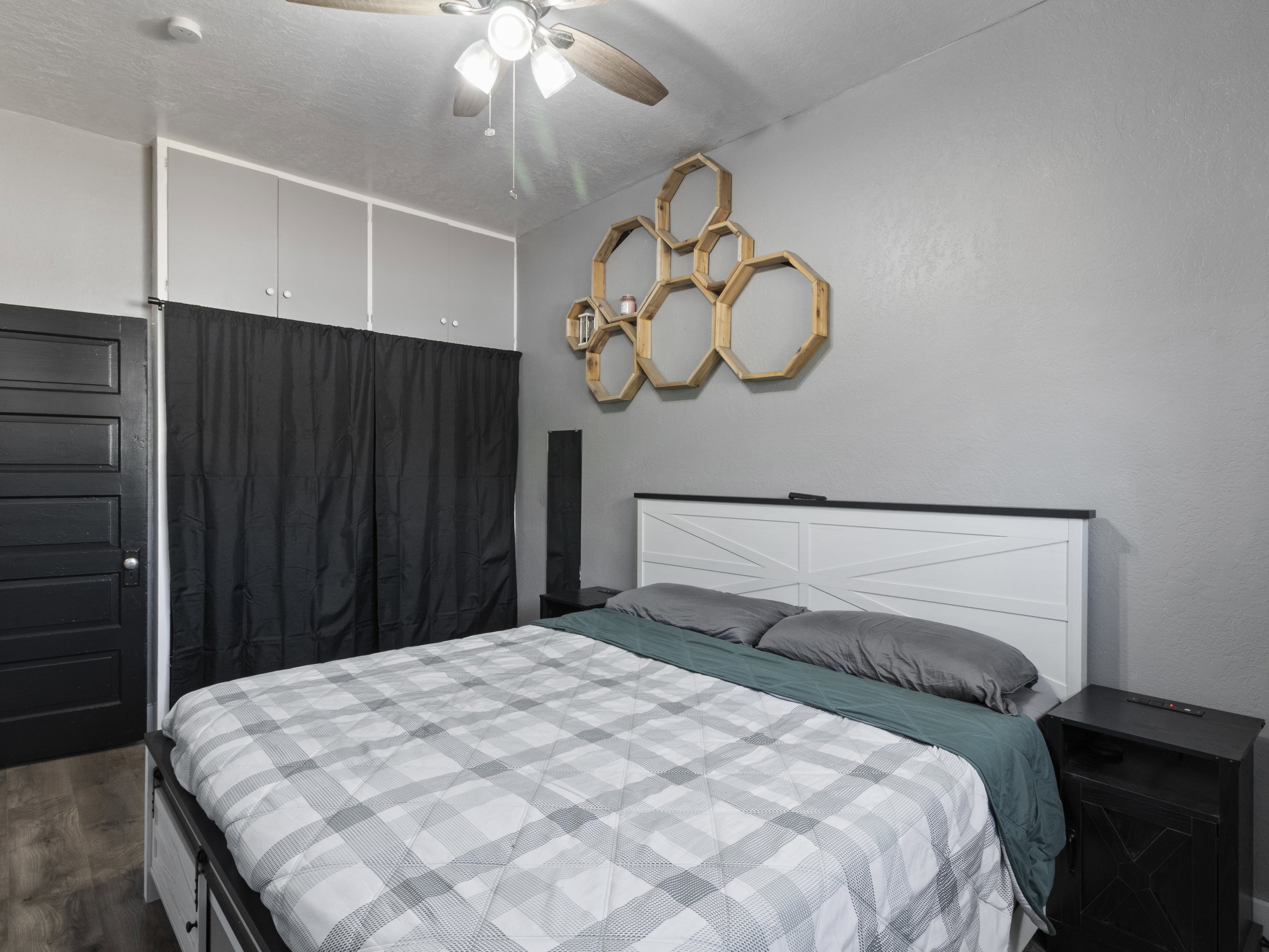 Bedroom with ceiling fan and dark wood-type flooring