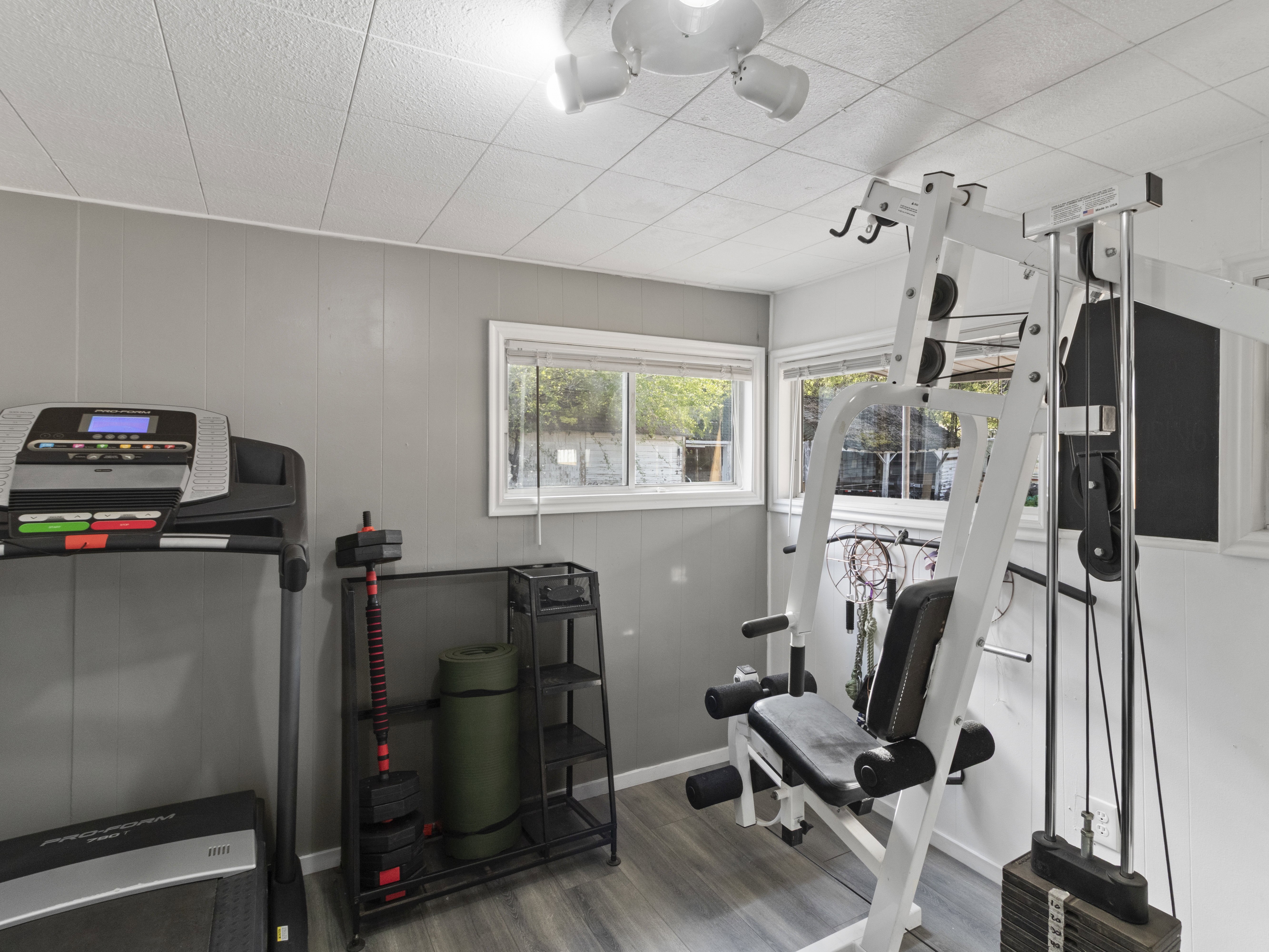 Workout room with dark wood-style floors and wooden walls