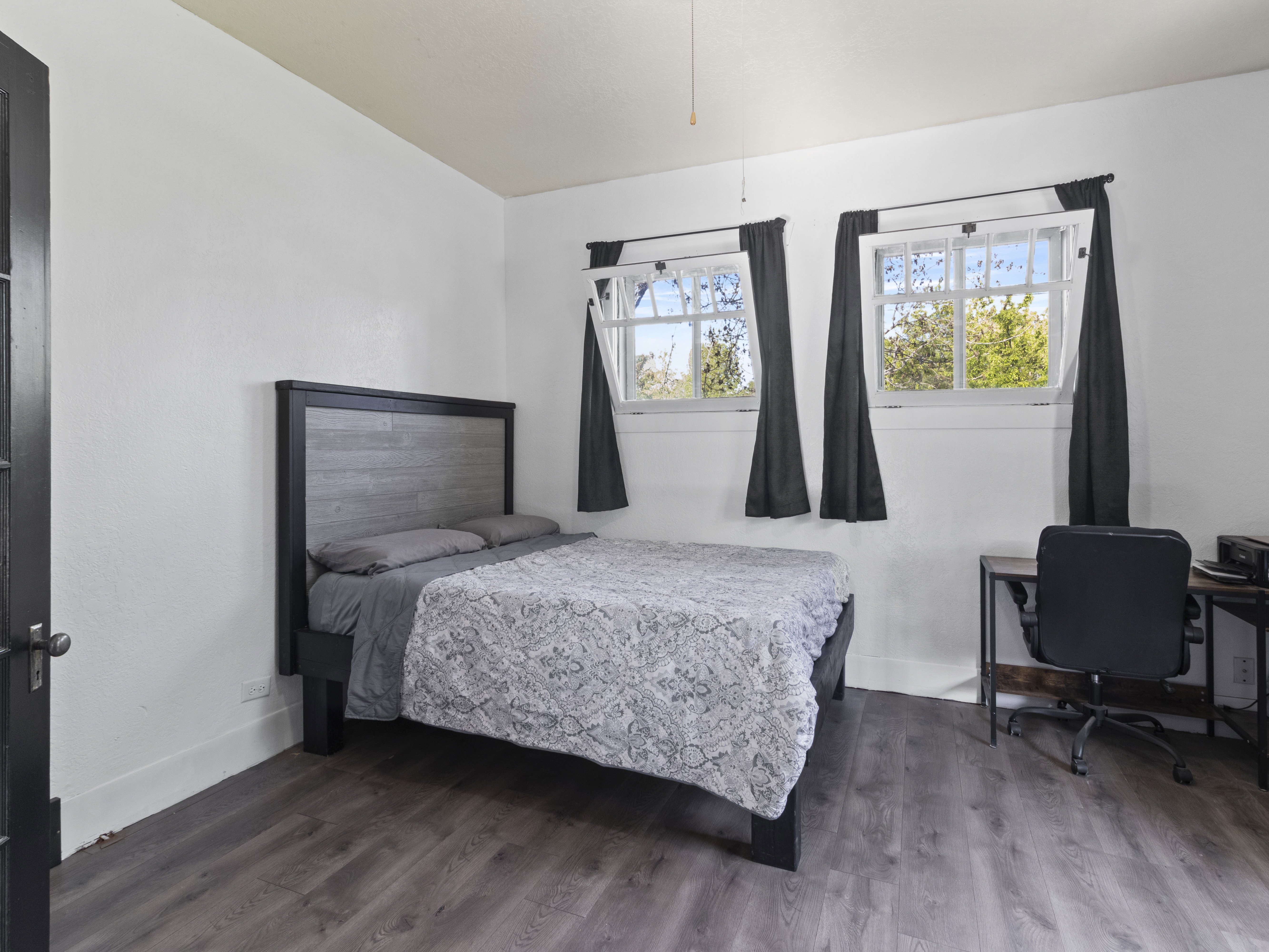 Bedroom featuring wood finished floors and an office area