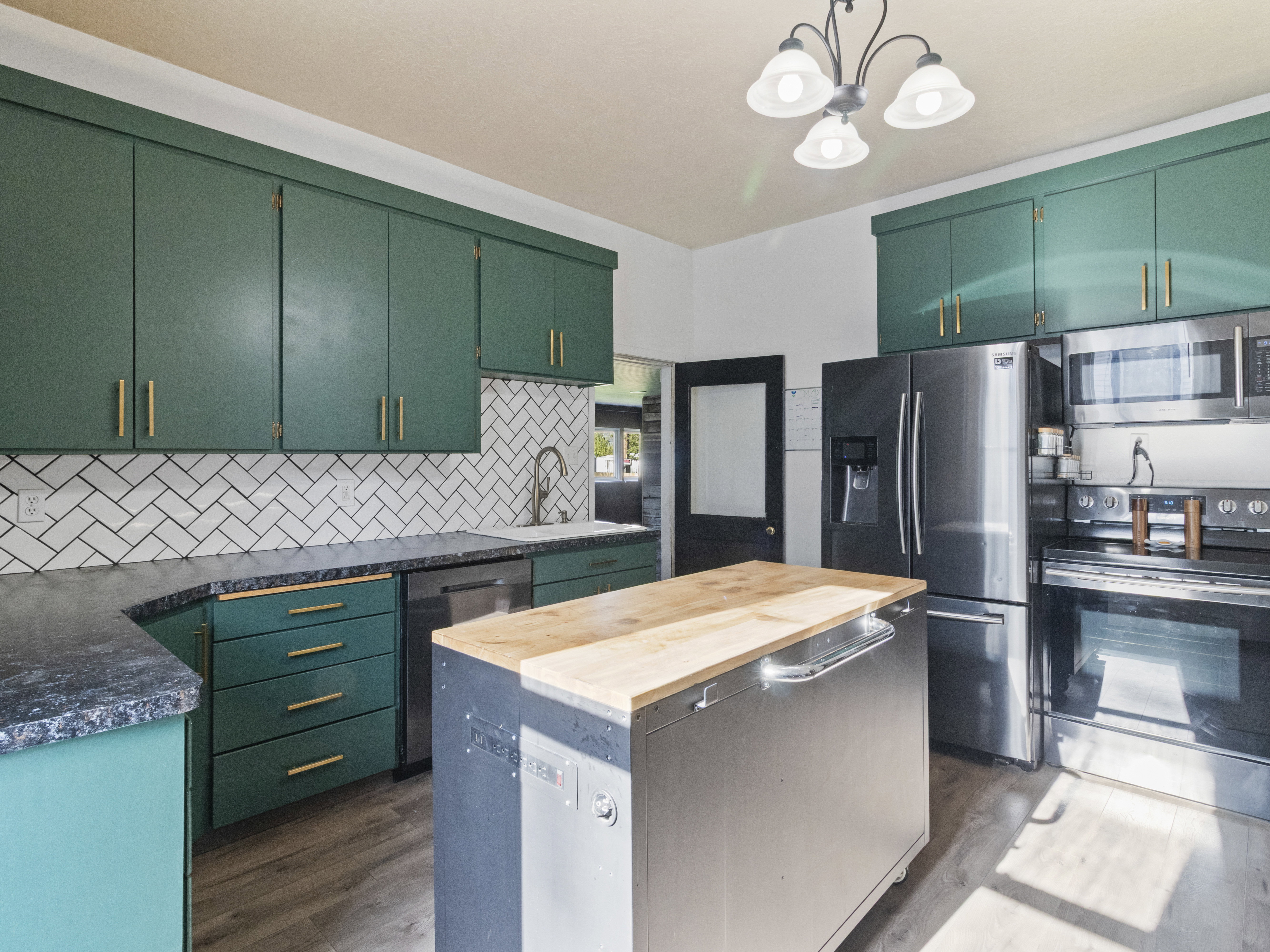 Kitchen featuring wood counters, stainless steel appliances, a kitchen island, and dark wood finished floors