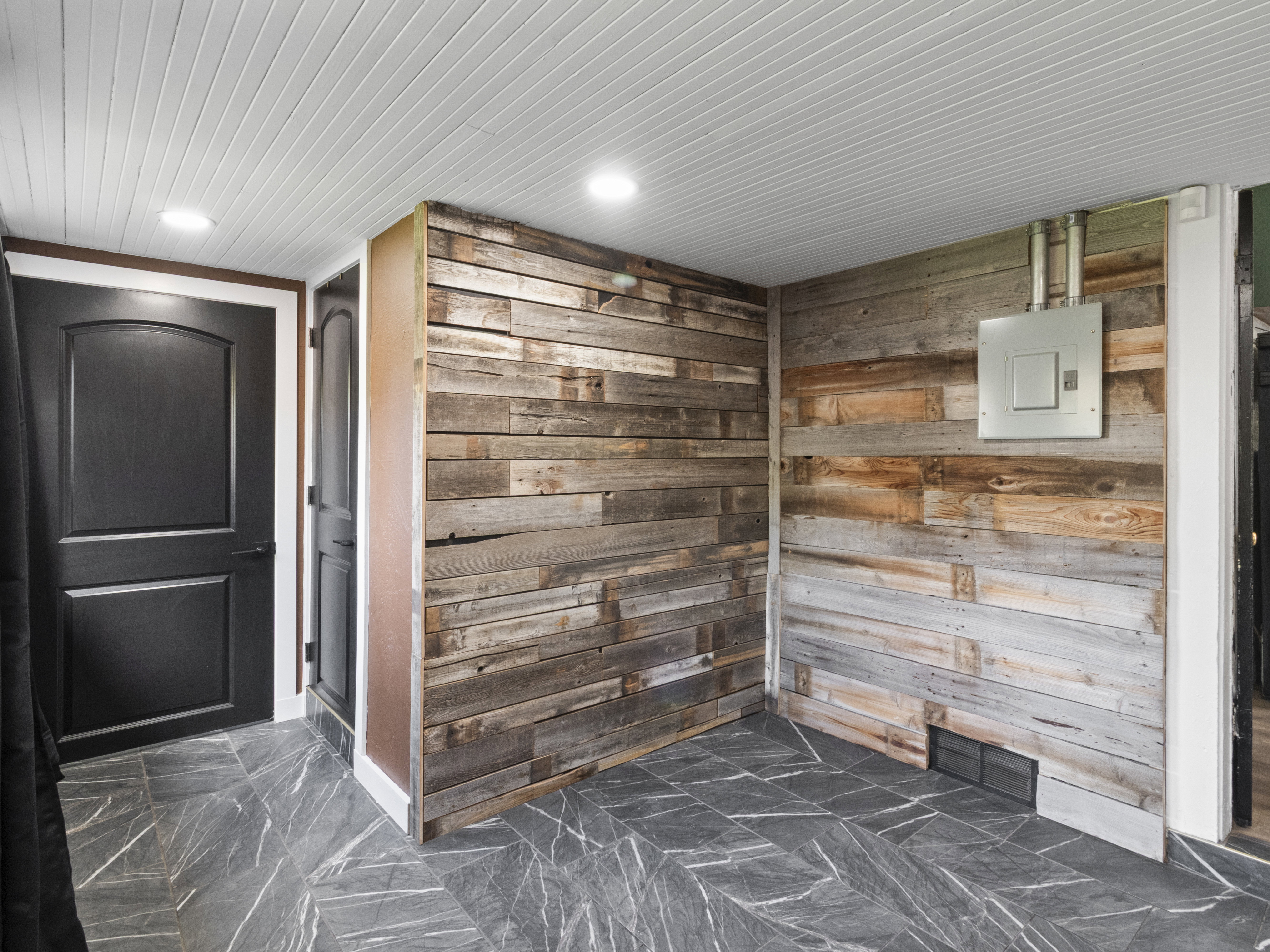 Mudroom featuring wood walls and electric panel