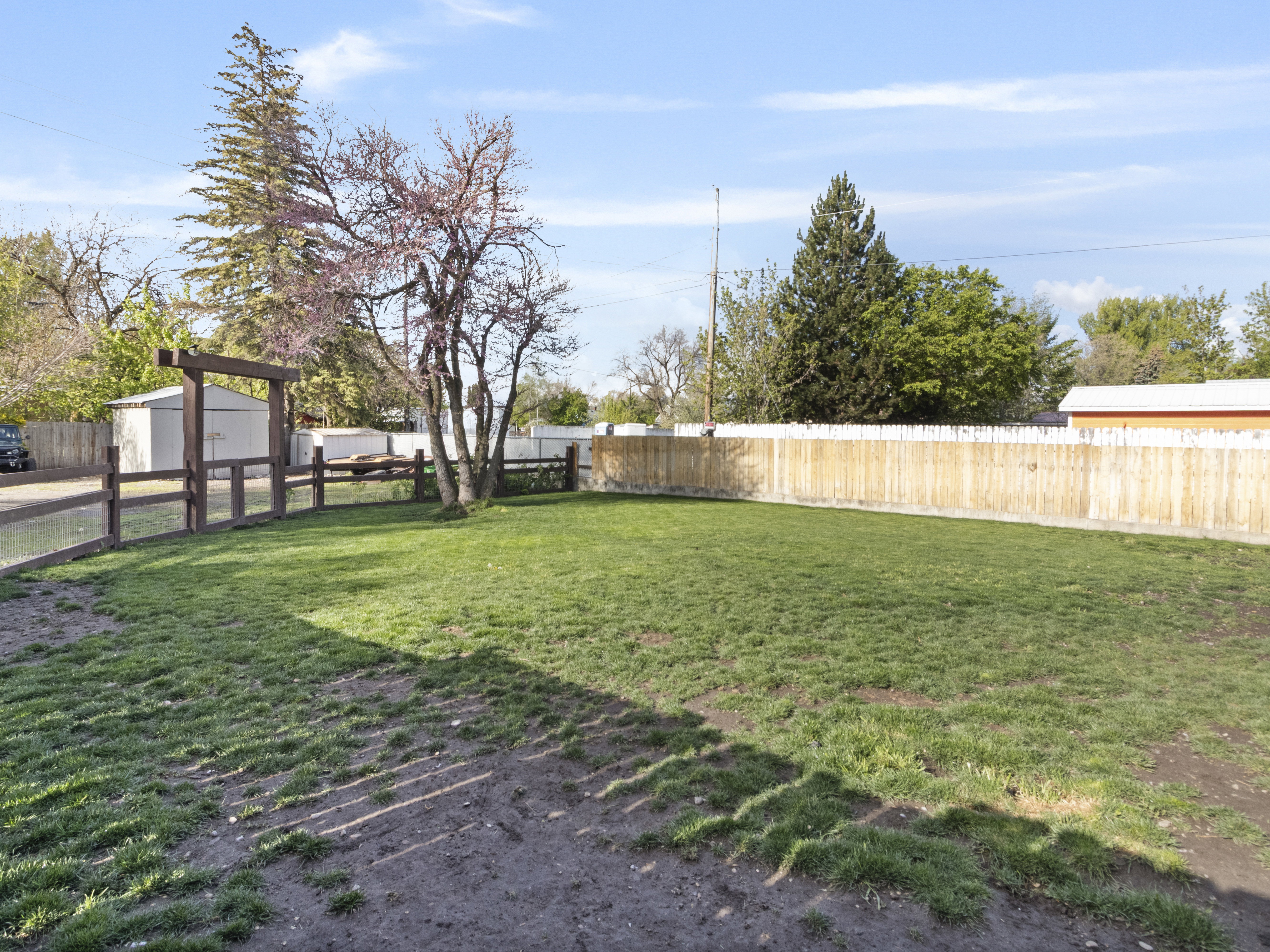 Fenced backyard featuring a storage shed