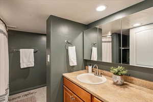 Bathroom with vanity, light tile patterned flooring, and recessed lighting