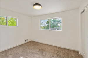 Spare room featuring carpet floors and plenty of natural light