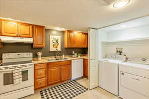 Kitchen featuring white appliances, wood finish cabinetry, light countertops, and recessed lighting