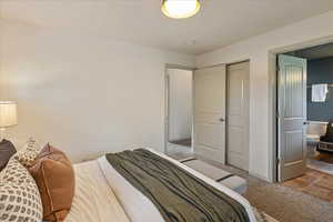 Bedroom with light colored carpet and connected bathroom