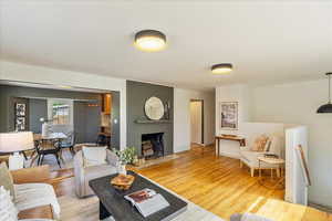 Living room with light wood finished floors and a brick fireplace