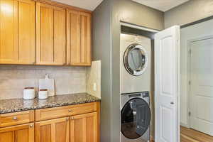Laundry area with stacked washer and clothes dryer