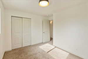 Unfurnished bedroom with a closet and light carpet