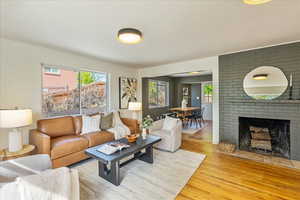 Living room featuring light wood-style flooring and a brick fireplace