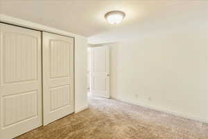Unfurnished bedroom featuring a closet and light carpet