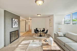 Living area with light colored carpet and a fireplace