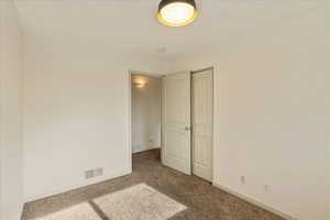 Unfurnished bedroom featuring carpet and a closet