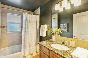 Full bathroom with shower / tub combo and vanity