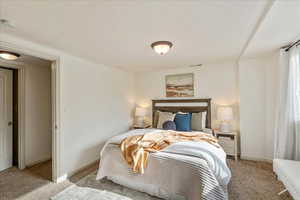 Bedroom featuring light carpet and baseboards