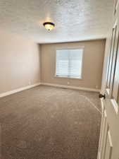 Carpeted room with a single window featuring horizontal blinds