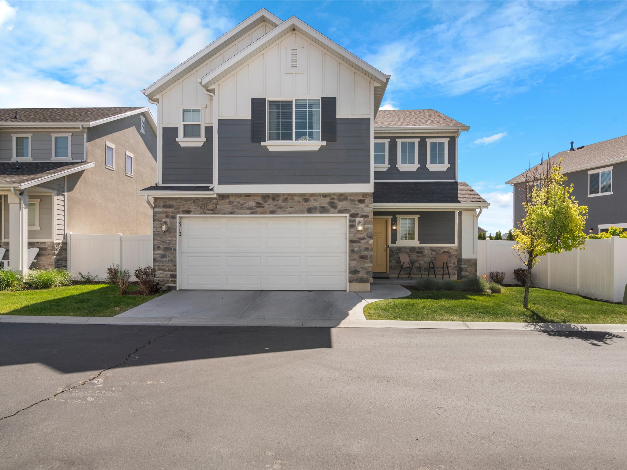 View of front of home featuring board and batten siding, stone siding, driveway, and an attached garage