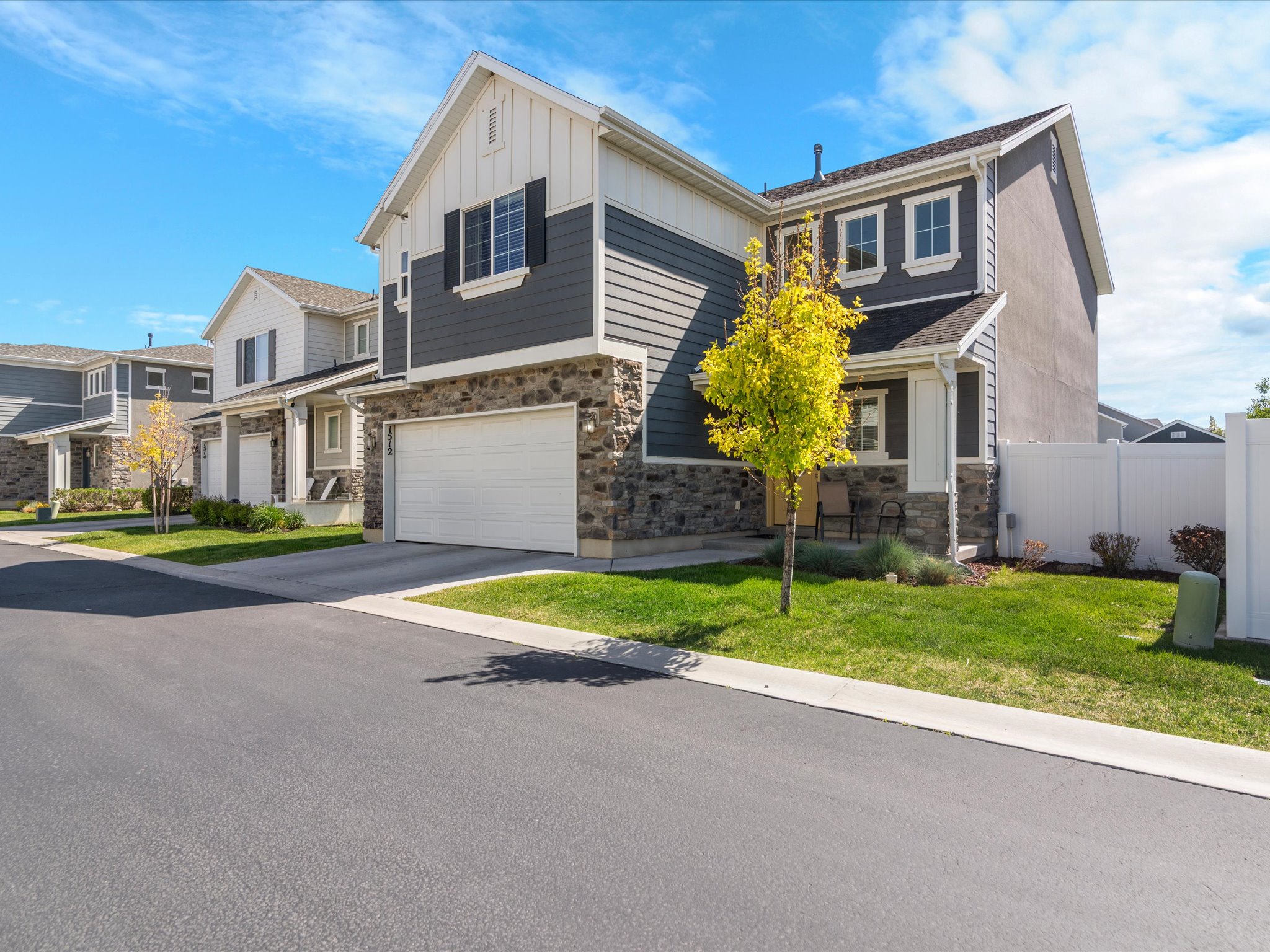 View of front of house featuring a garage, stone siding, board and batten siding, and concrete driveway