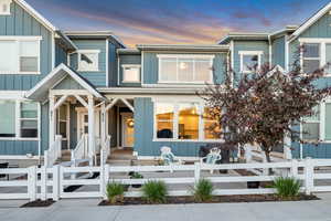 View of front of home with board and batten siding, a porch, and a fenced front yard