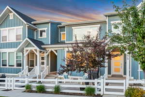 View of front of property featuring board and batten siding, a shingled roof, and a fenced front yard