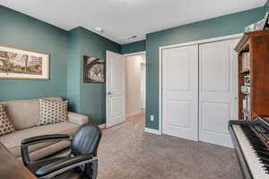 Office space with light carpet and a textured ceiling