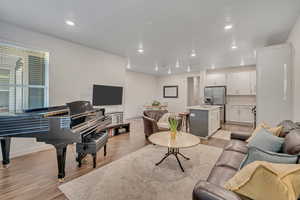 Living area featuring light wood finished floors and recessed lighting