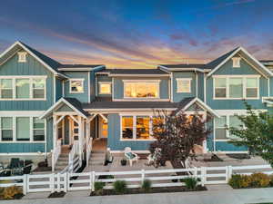 View of front of home with board and batten siding, a fenced front yard, covered porch, a gate, and a shingled roof
