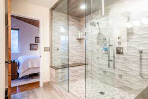 Beautifully updated primary bathroom with dual vanities, refined finishes, and a spa-like walk-in shower