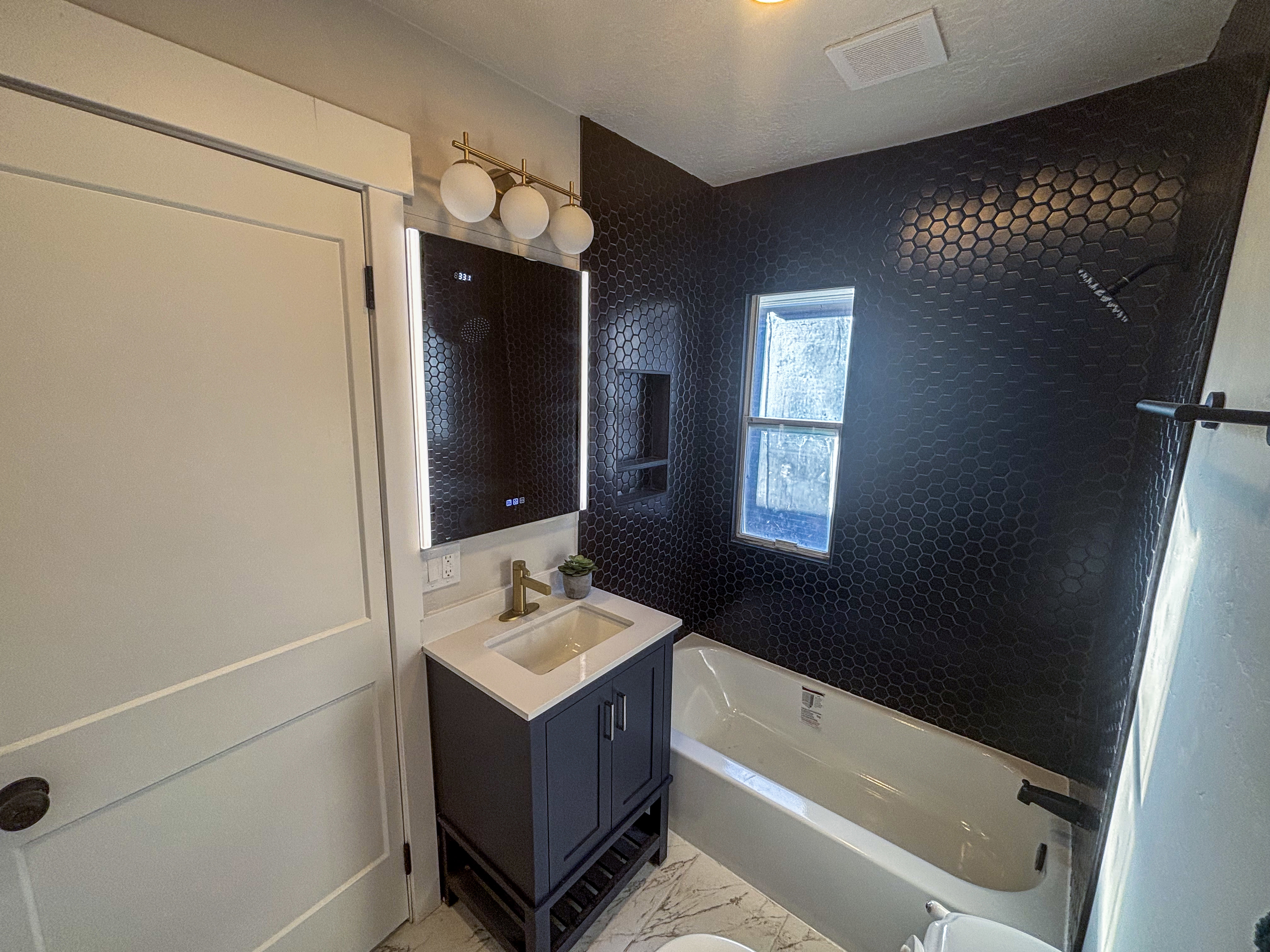 Full bathroom featuring vanity, a bathtub, light marble finish floors, and a shower