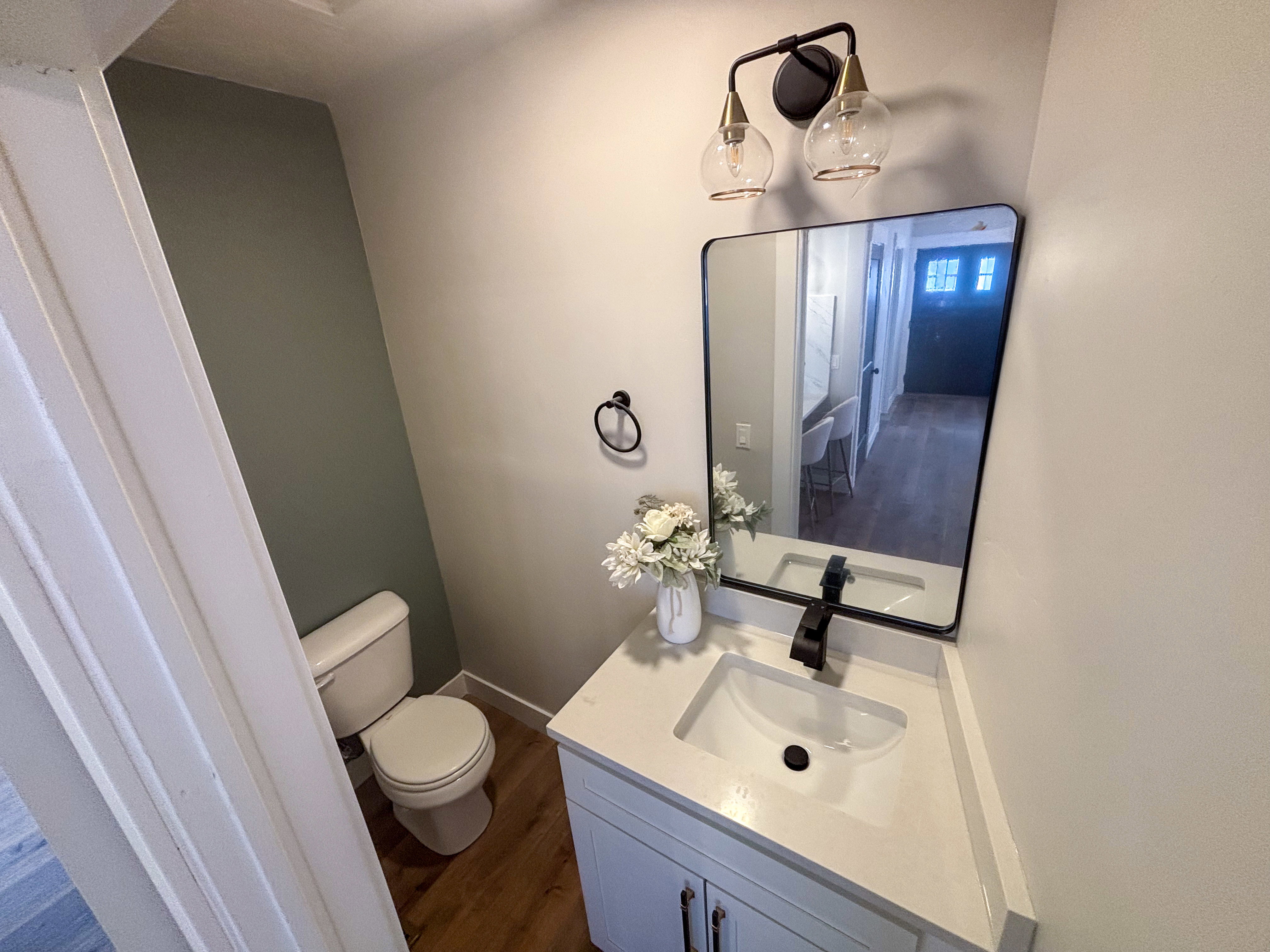Half bath featuring dark wood finished floors and vanity