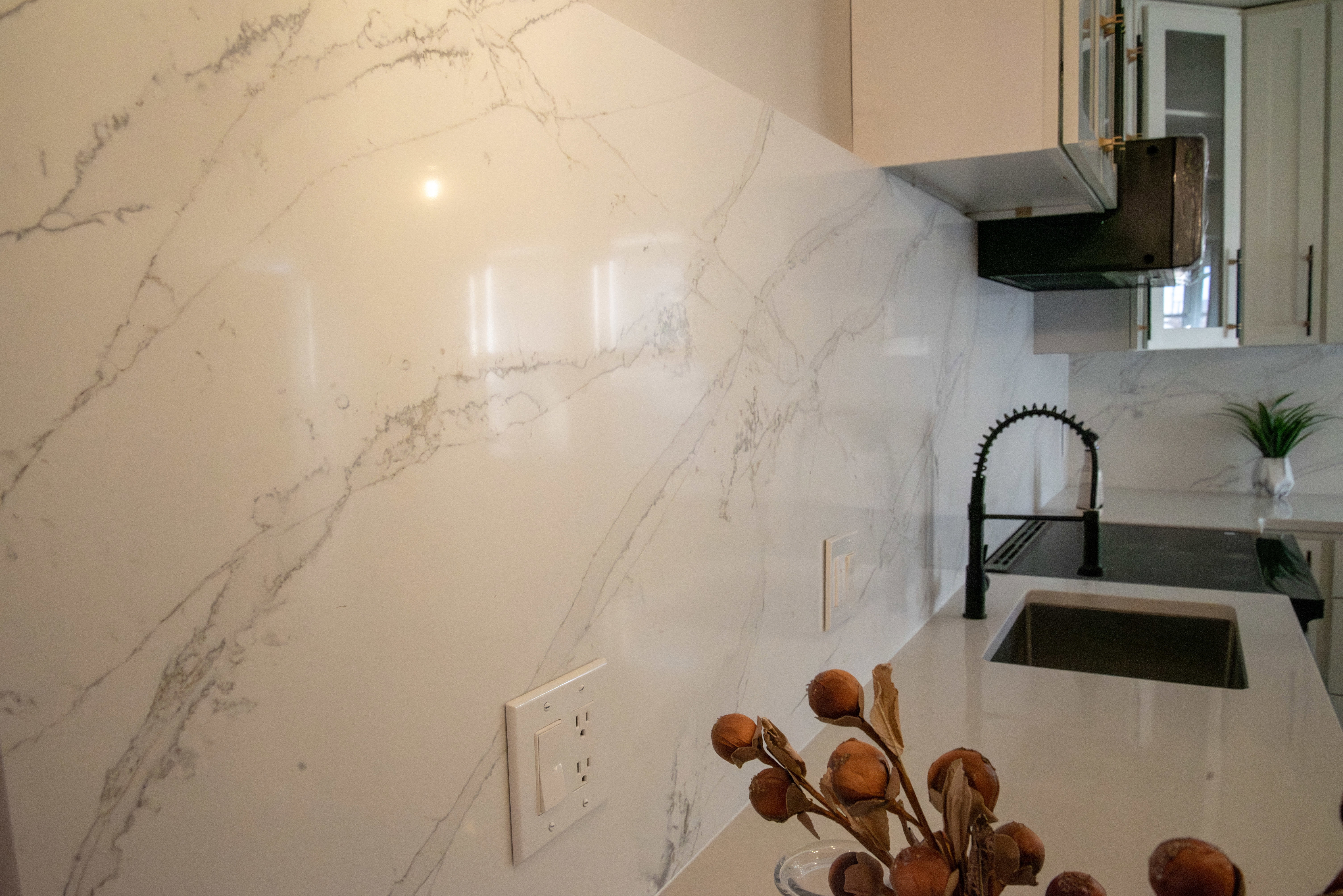 Kitchen featuring glass fronted cabinets and light stone counters