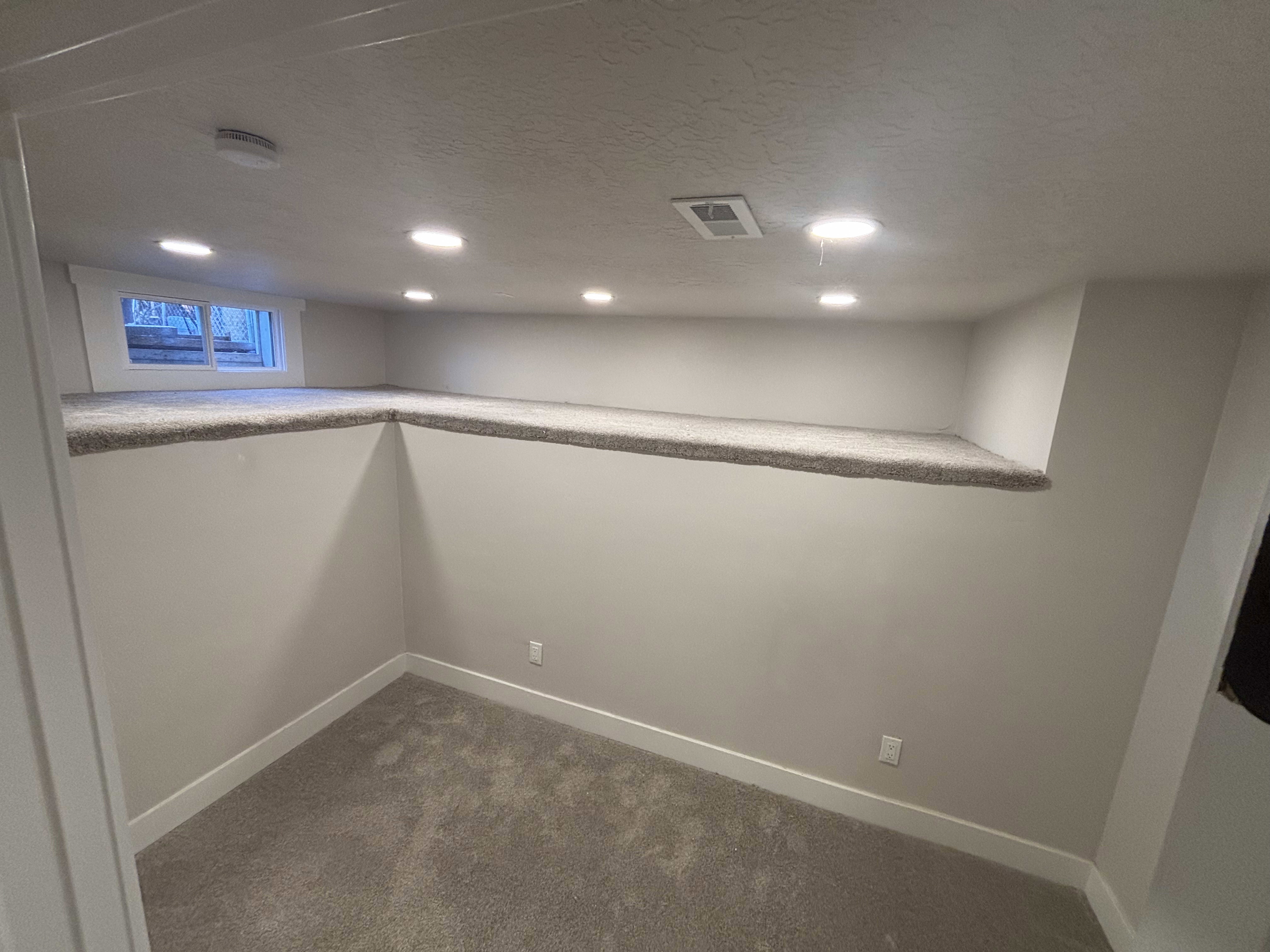 Below grade area featuring dark colored carpet, a textured ceiling, and recessed lighting