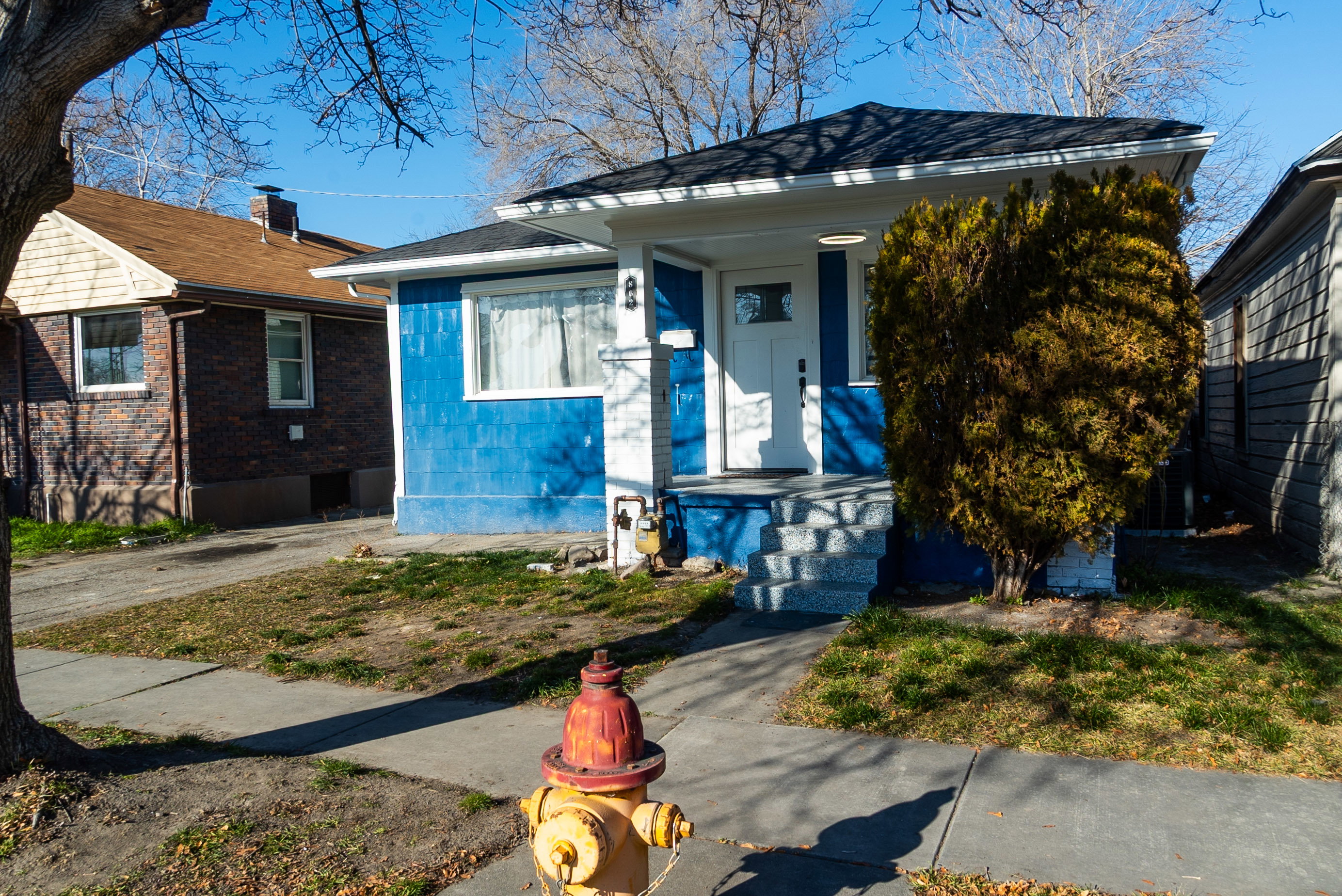 View of front of house with concrete block siding and roof with shingles