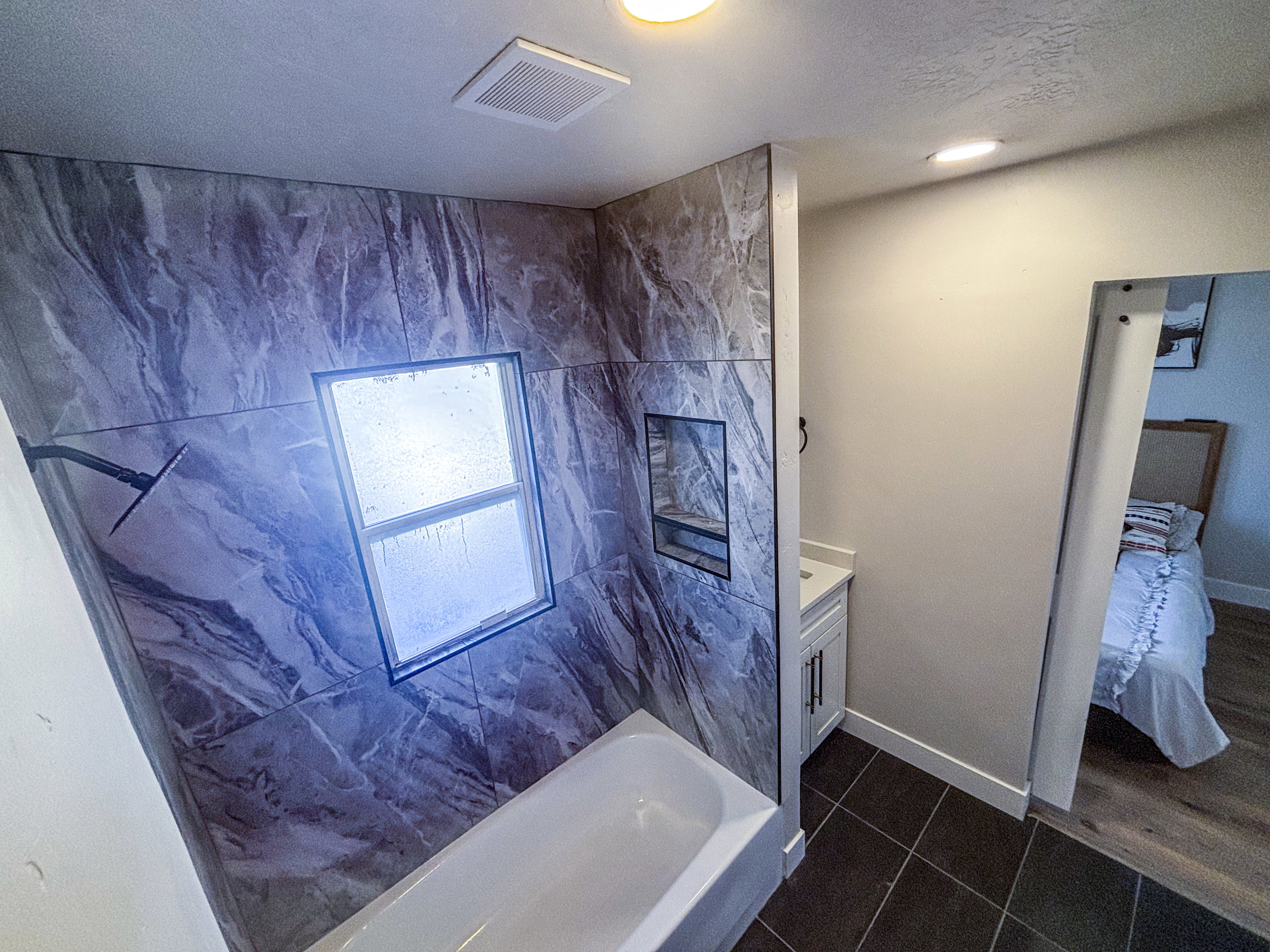 Full bath with vanity, dark tile patterned flooring, ensuite bath, a shower, and a textured ceiling