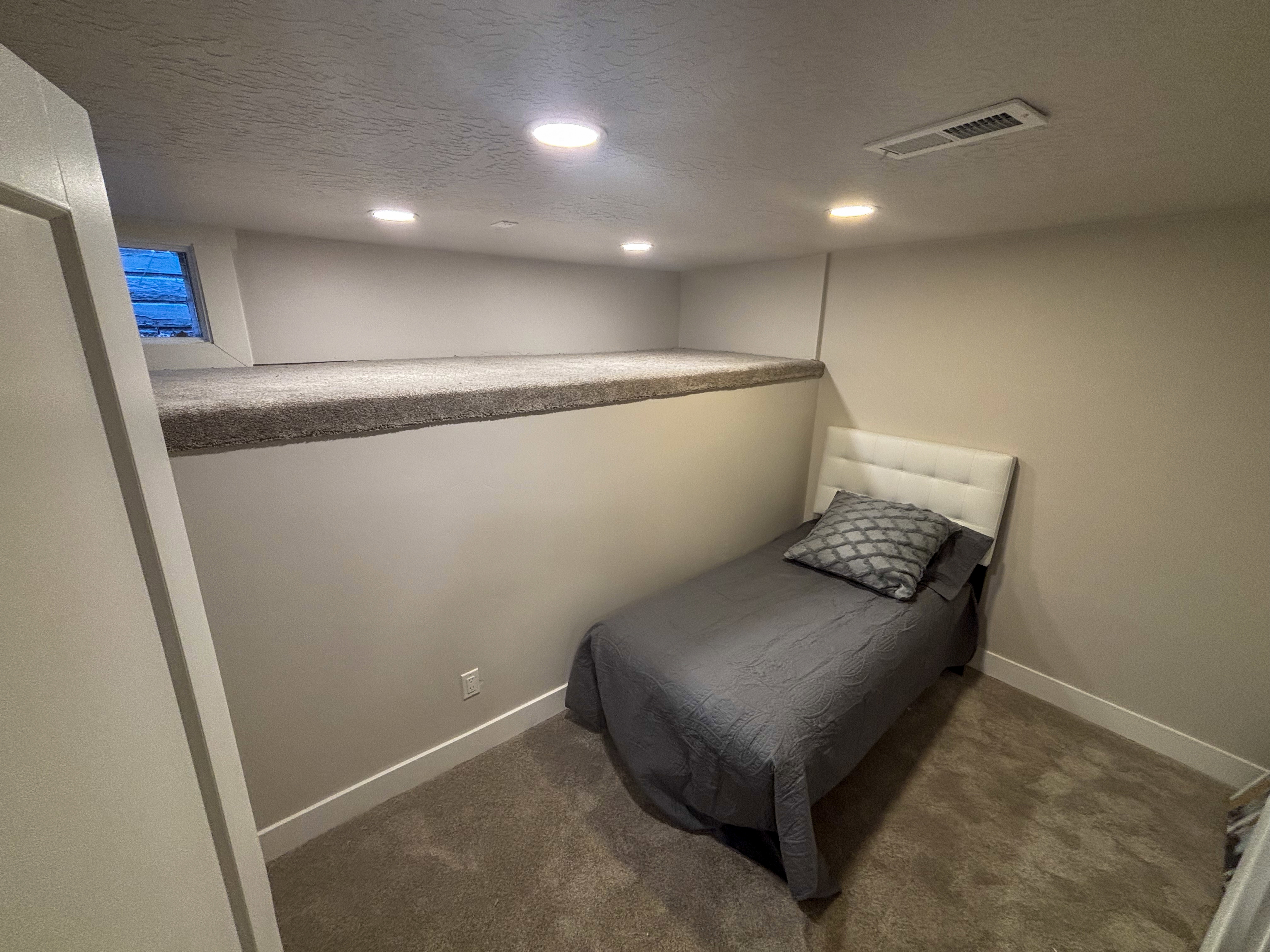 Bedroom with a textured ceiling, dark carpet, and recessed lighting