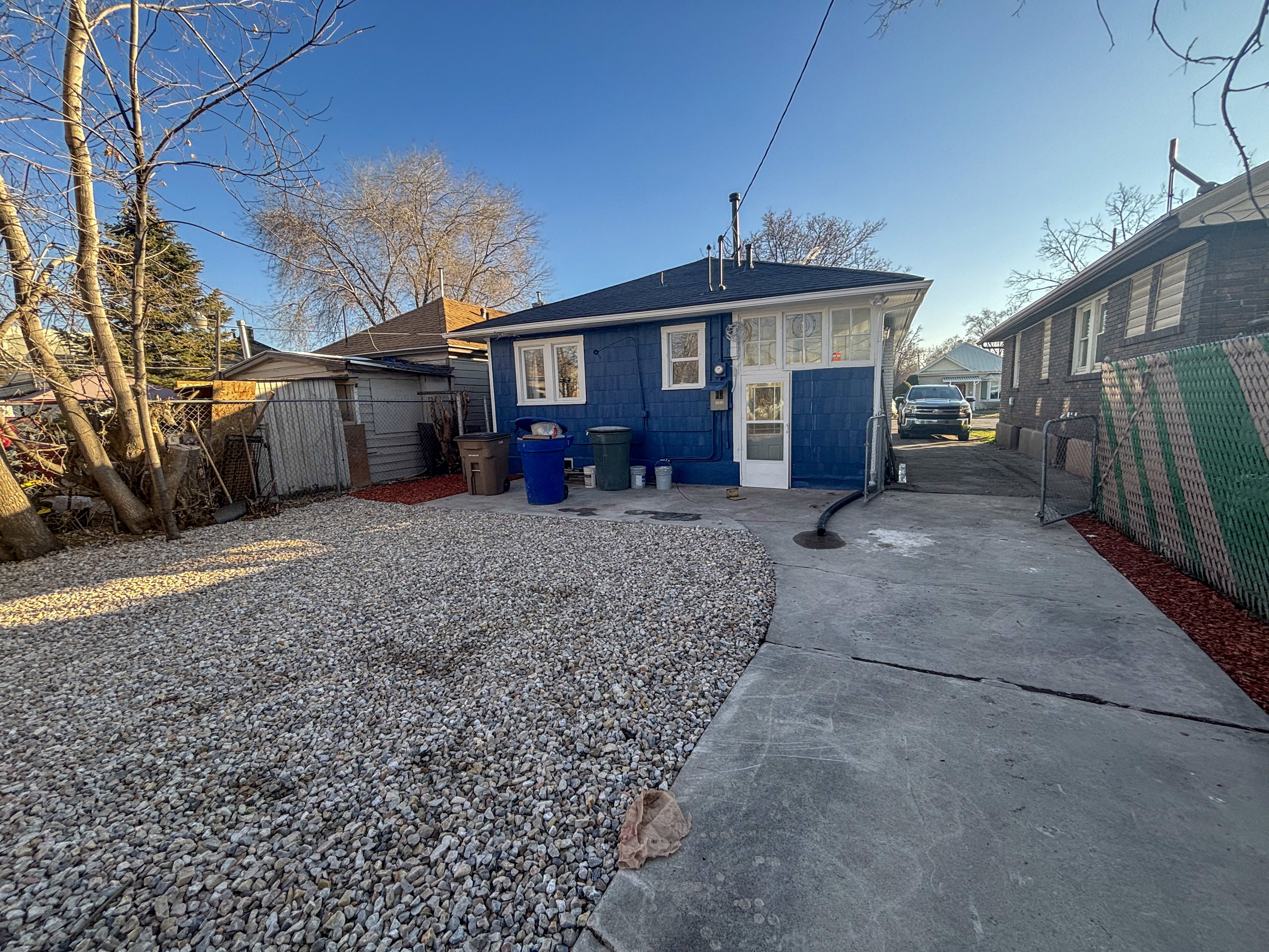 Back of house featuring concrete driveway, a patio, and roof with shingles