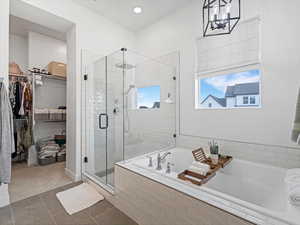 Full bath featuring a walk in closet, a stall shower, a garden tub, tile patterned floors, and recessed lighting