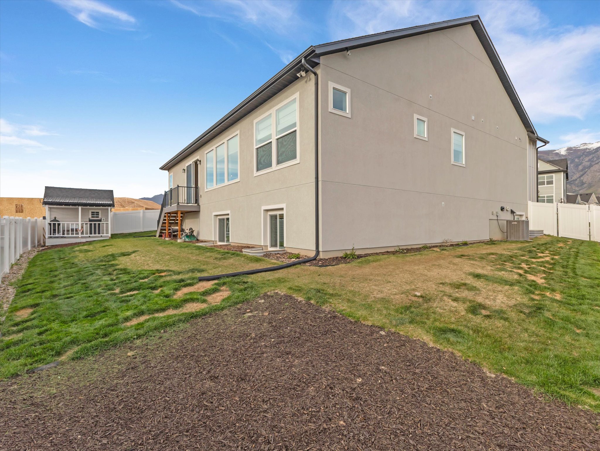 Back of property with a fenced backyard and stucco siding