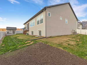 Back of property with a fenced backyard and stucco siding