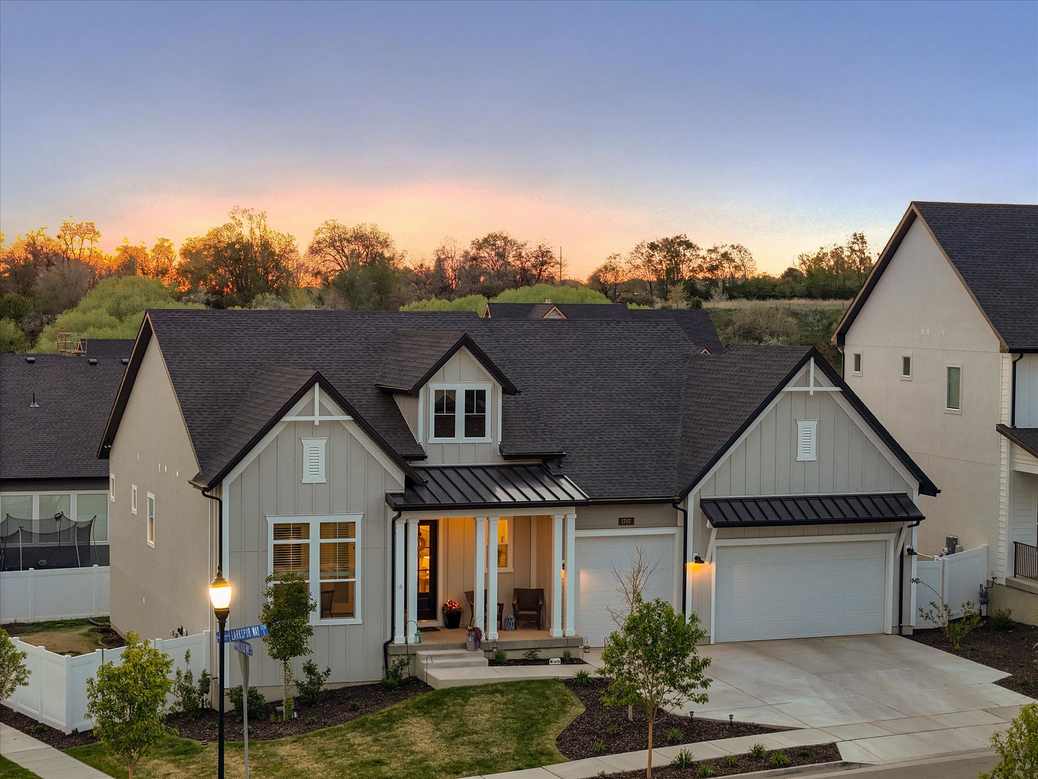 Modern farmhouse featuring a standing seam roof, board and batten siding, a shingled roof, and a porch