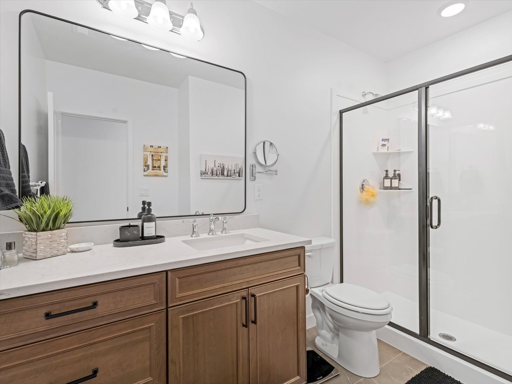 Full bathroom with vanity, a shower stall, and light tile patterned floors