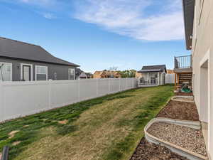 Fenced backyard with a residential view and an outbuilding