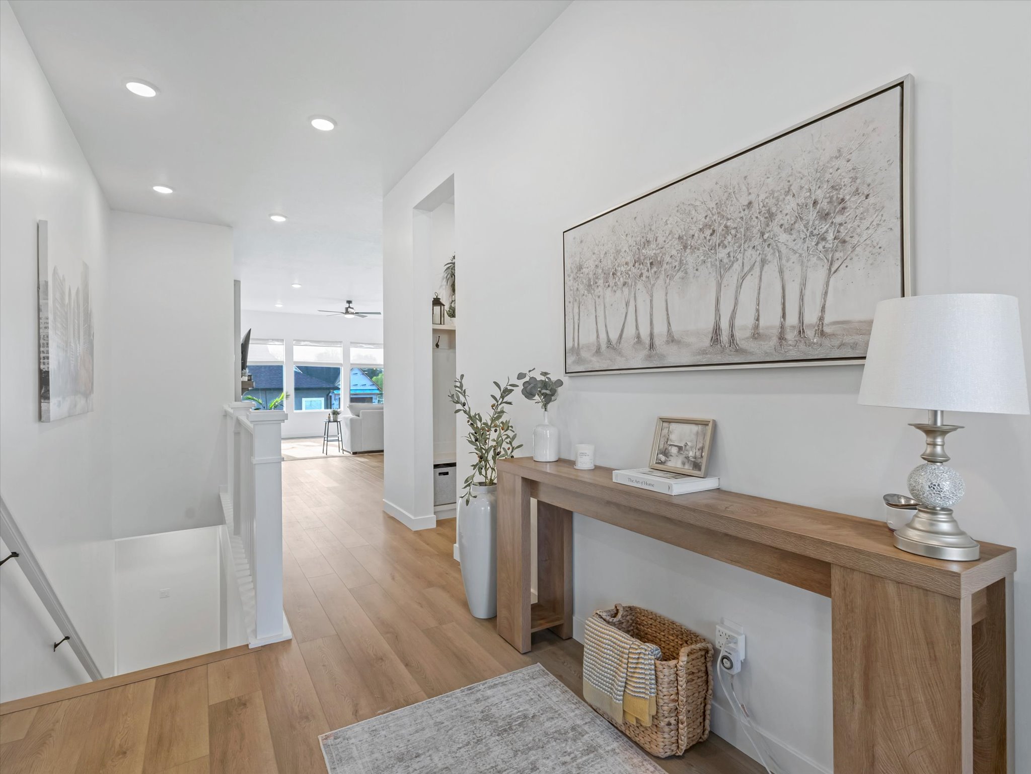 Corridor with an upstairs landing, light wood-style floors, and recessed lighting