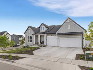 Modern farmhouse style home with board and batten siding, a porch, roof with shingles, a standing seam roof, and driveway