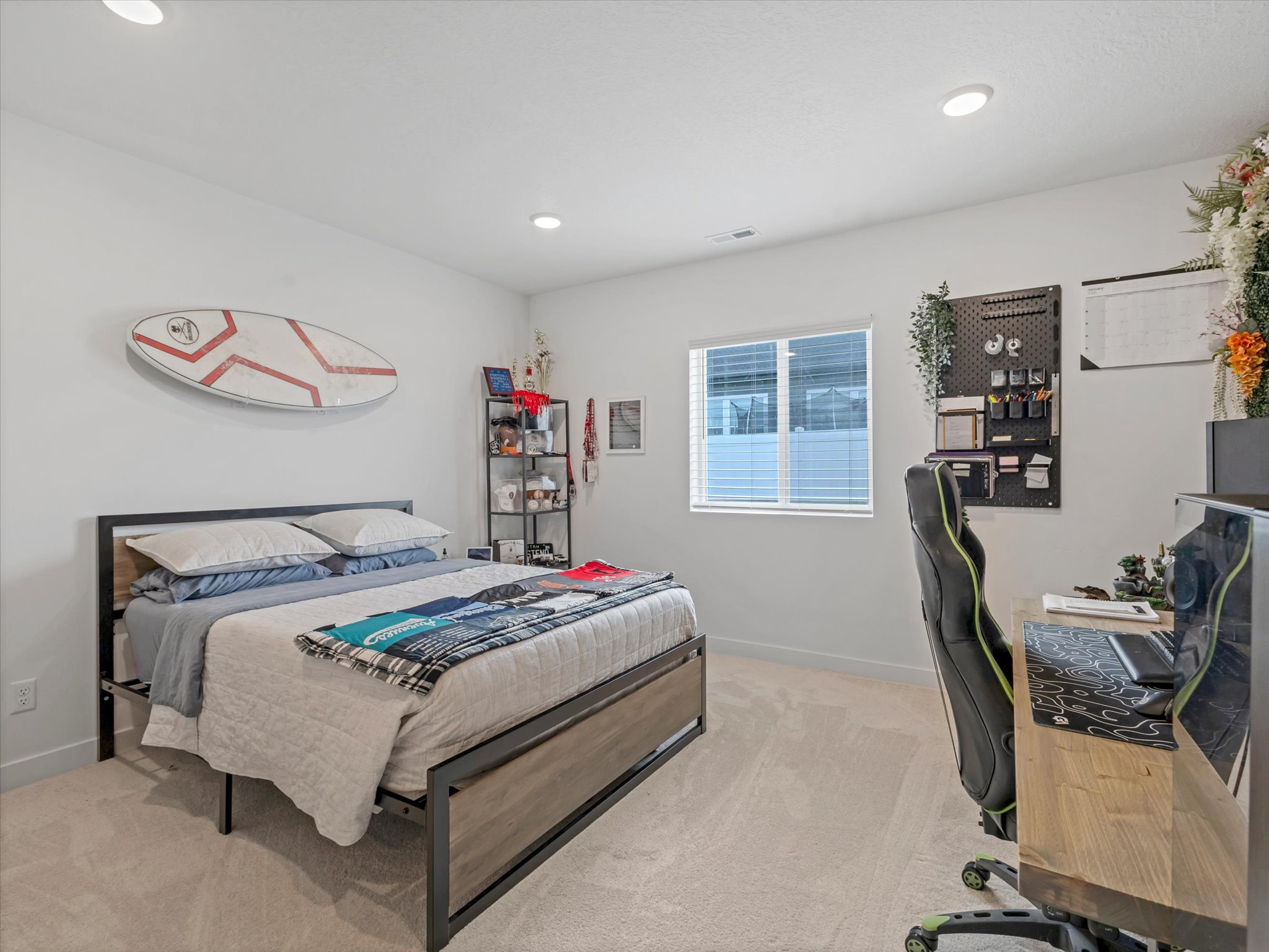 Bedroom with light colored carpet, an office area, and recessed lighting