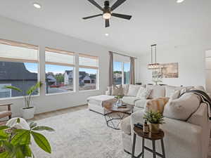 Living area with ceiling fan, light wood-style floors, and recessed lighting